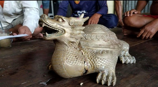 Tượng thú lạ có hình long quy (thân rùa, đầu rồng) màu vàng ánh như đồng, nặng 9,6kg. Ông Nguyễn Hồng Trợ cho biết, ông giẫm đạp lên tượng thú lạ, làm gãy phần đầu. Bên trong bụng tượng có chứa nhiều mẫu vật lạ, nhiều màu sắc như: gỗ, kim, chỉ, các mẫu xương (chưa xác định).