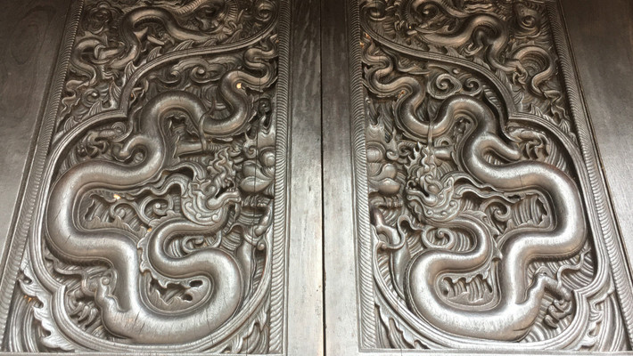 Bộ cánh cửa 4 cánh ở gian giữa nhà Tiền đường, chùa Phổ Minh đều chạm khắc hình con rồng với tư thế đầu ngẩng cao, thân uốn khúc, đuôi chụm về phía đỉnh lá đề.