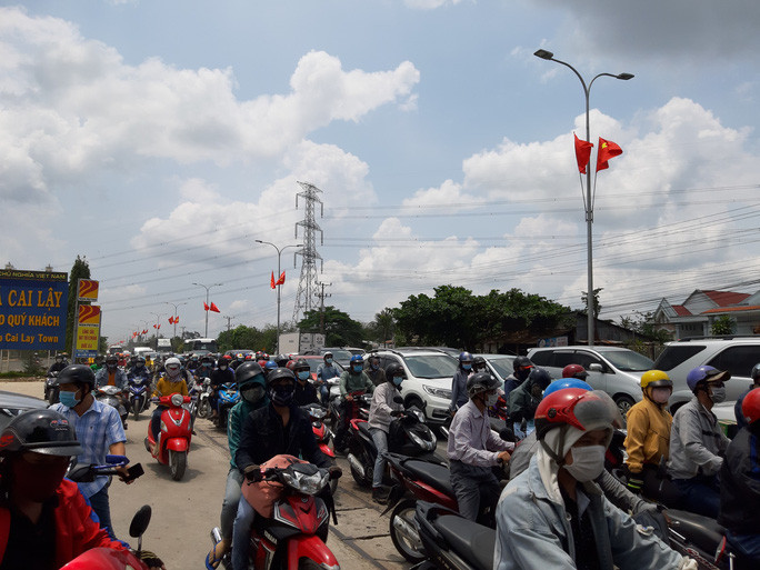 Trên Quốc lộ 1, các phương tiện di chuyển chậm và có nhiều điểm ùn ứ như tại các nút giao ngã tư Lương Phú, ngã tư Đồng Tâm… Khu vực cầu Rượu, các phương tiện chen lấn và ùn ứ kéo dài đến gần ngã tư Đồng Tâm (huyện Châu Thành). (Ảnh: Người lao động)