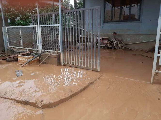 Bùn đóng lớp dày, nhão nhoẹt trước sân nhà dân sau khi lũ rút. Ảnh: Tiền Phong.