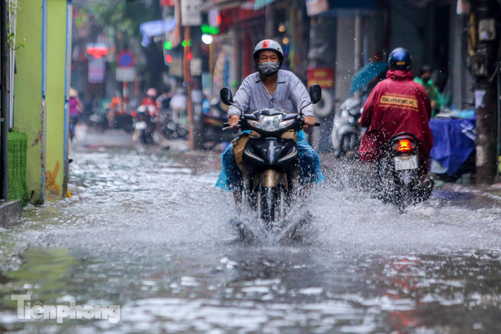 Xe máy cố gắng lao qua biển nước.
