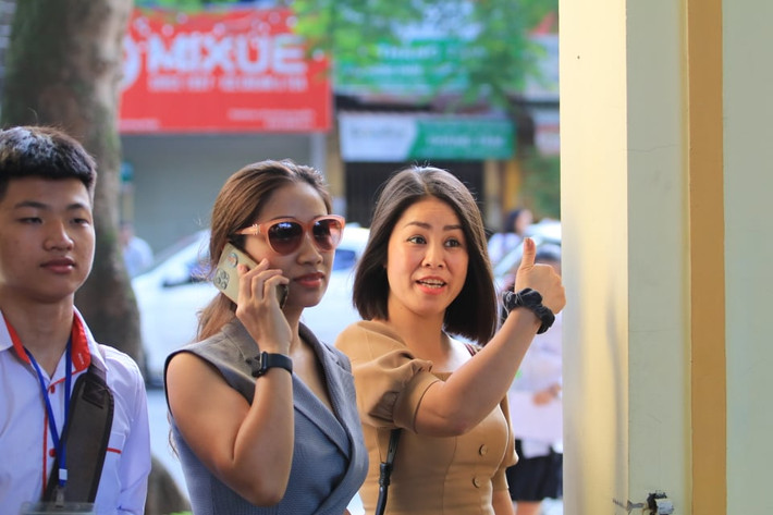 Một phụ huynh động viên trước khi vào phòng thi. (Ảnh: Báo Tin Tức)