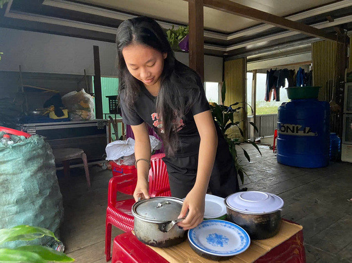 Em Trương Tâm Đan, thôn 2 Yên Thọ chuẩn bị bữa tối cho gia đình trên nhà phao. Ảnh: CTV