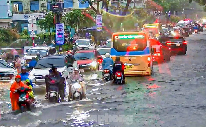 Nhiều xe máy phải nối đuôi nhau để vượt qua những đoạn ngập sâu.