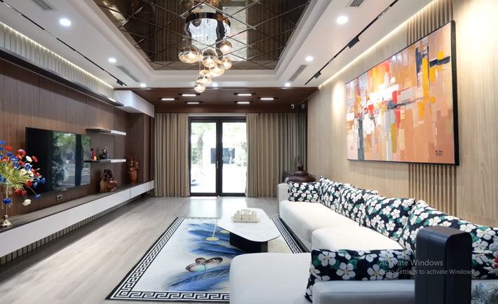 Ngôi nhà được thiết kế theo phong cách hiện đại. Trong phòng khách, kiến trúc sư sử dụng màu gỗ có thiên hướng tự nhiên nhưng chất liệu hầu hết là gỗ công nghiệp.