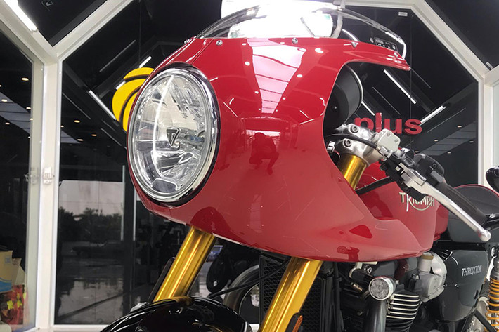 Thruxton bản có quây gió vẫn giữ nguyên thiết kế phần đầu đơn giản với đèn pha dạng "gáo dừa" lớn ở phía trước với logo nổi chữ T ở chính giữa, kèm theo dòng chữ Triumph ở dưới đáy. Với phụ kiện quây gió (fairing) chính hãng, một bộ quây bao quanh đèn pha đã biến kiểu dáng của chiếc xe trở nên giống xe đua hơn.