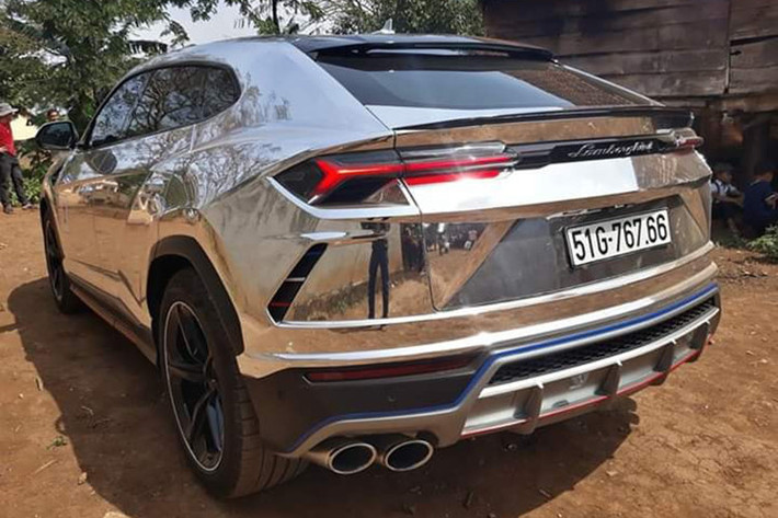 Trước Tết nguyên đán, Minh Nhựa cũng đã cho chiếc siêu SUV Lamborghini Urus khoác áo mới màu crôm đen cá tính. Chưa hết, bộ mâm 5 chấu đơn màu bạc nguyên bản của xe cũng được cho sơn lại thành màu đen. Ngoài bộ áo crôm đen, xe còn được Minh Nhựa cho tạo thêm điểm nhấn bao gồm các sọc màu xanh đỏ và trắng ở lưới tản nhiệt phía trước.