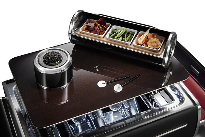 Bởi những đại gia siêu giàu có thể không muốn liên tục giữ trên tay một trong 4 chiếc ly thủy tinh đẹp mắt, chiếc vali có hẳn một cái bàn gỗ nhỏ Tudor Oak – hoàn thiện với khung thép chống gỉ cắt laser – mà dựng lên với chỉ một nút bấm.