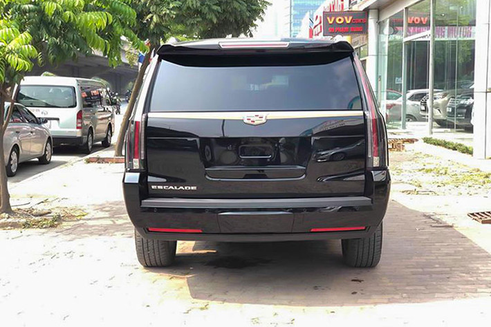 Cụm đèn hậu là một dải đèn LED đặt dọc phần góc đuôi xe tạo nên điểm nhận diện không lẫn vào đâu của Cadillac Escalade. Gương chiếu hậu chỉnh điện tích hợp đèn xi-nhan báo rẽ. Logo Cadillac gắn trên nẹp kim loại mạ chrome sáng tại đuôi xe, phía dưới là camera lùi nằm trong hệ thống camera 360 độ.