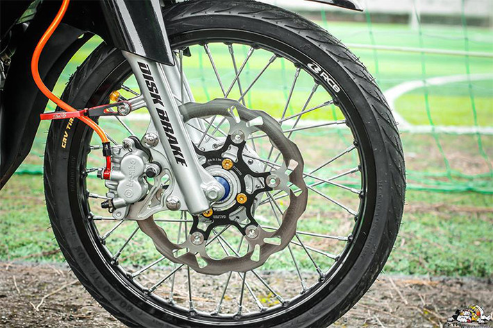 Niềng nhôm Racing boy màu đen mang lại sự cứng cáp cho dàn chân với tone màu đen, hệ thống phanh được nâng cấp với đĩa Galfer được đính chặt bằng ốc vàng kết hợp cùng heo Brembo KTM, dây dầu nổi bật với sắc màu cam được cố định bằng pass kẹp dầu CNC .