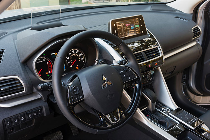 Bên trong nội thất, bảng táp-lô của Eclipse Cross thiết kế chia tầng rõ rệt. Những đường viền ốp chạy ngang bảng táp-lô, cắt dọc từ bệ trung tâm màu kim loại đem tới cho xe cảm giác hiện đại, năng động hơn. Vô-lăng trên mẫu xe này thiết kế 3 chấu, bọc da được lấy cảm hứng từ Outlander.