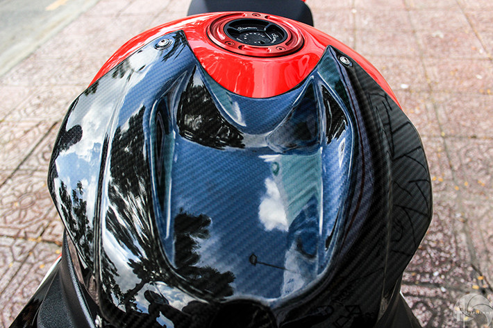 Bình xăng của xe được chủ nhân trang bị ốp carbon fiber cực chất với màu đen bóng lộn kết hợp với màu đỏ ớt khiến nó nổi bật hơn rất nhiều.