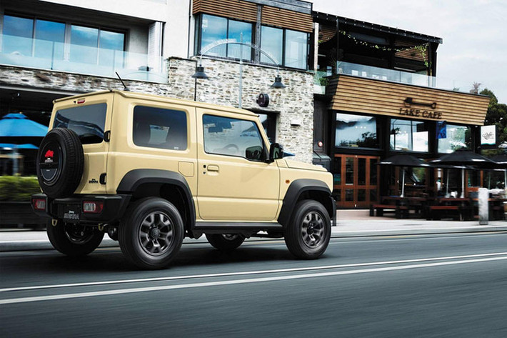 Suzuki Jimny phiên bản 2019 là mẫu xe off-road, gầm xe cao sở hữu cụm đèn pha tròn cổ điển. Bộ lưới tản nhiệt của xe được phủ sơn màu đen cách nhiệt cùng logo chữ “S” đính ở chính giữa. Phần đuôi phía sau được trang bị một bánh xe dự phòng gắn trên nắp ca-pô sau.
