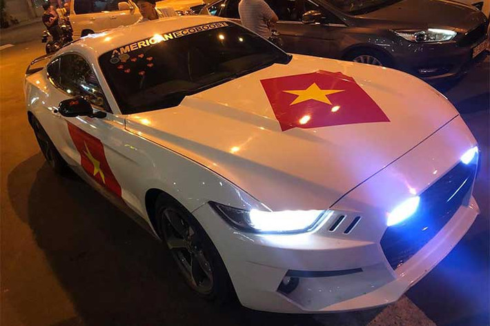 Ford Mustang tiền tỷ độ bodykit "khủng" tại TP HCM mang tên gọi Rocket với cờ đỏ sao vàng dán trên thân xe xuống phố diễu hành.