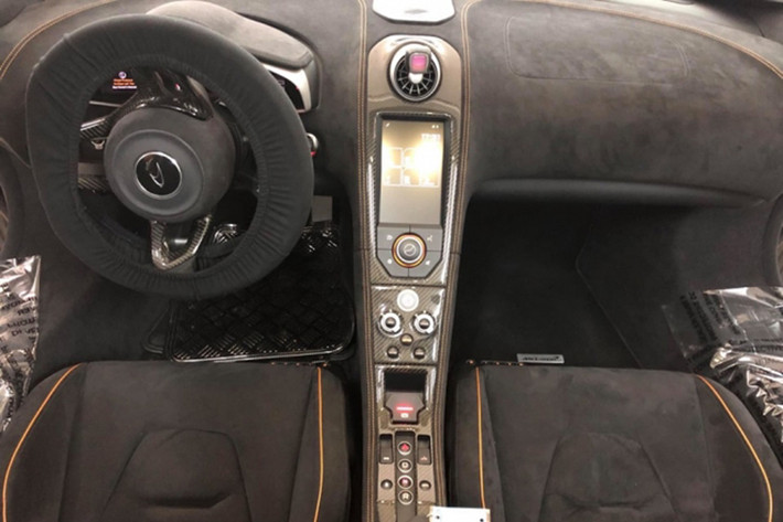 Giống những mẫu siêu xe từ trước tới nay của McLaren, 650S Spider cũng sở hữu cửa mở lật độc đáo. Nội thất của xe được bọc da Alcantara kết hợp cùng các đường chỉ cam may tinh xảo ở ghế ngồi, bảng điều khiển trung tâm, thành cửa hay vô lăng thể thao của xe. Tất nhiên, bên trong khoang lái siêu xe này còn có nhiều chi tiết sợi carbon.