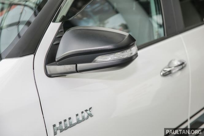 Thân xe được dán decal đen kéo dài tới đuôi xe, ngoài ra xe còn được trang bị ốp gầm bảo vệ cản va... Vỏ gương của Toyota Hilux 2.4G AT Limited Edition đã chuyển từ mạ crôm sang sơn đen - những chi tiết này càng làm tăng thêm vẻ hầm hố cho mẫu xe bán tải phiên bản giới hạn.