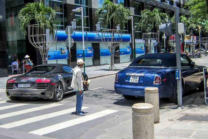 Trên đường phố Sài Gòn, Audi R8 bất gờ "đụng độ" siêu xe sang Rolls-Royce Drophead Coupe màu xanh đang đậu bên đường.