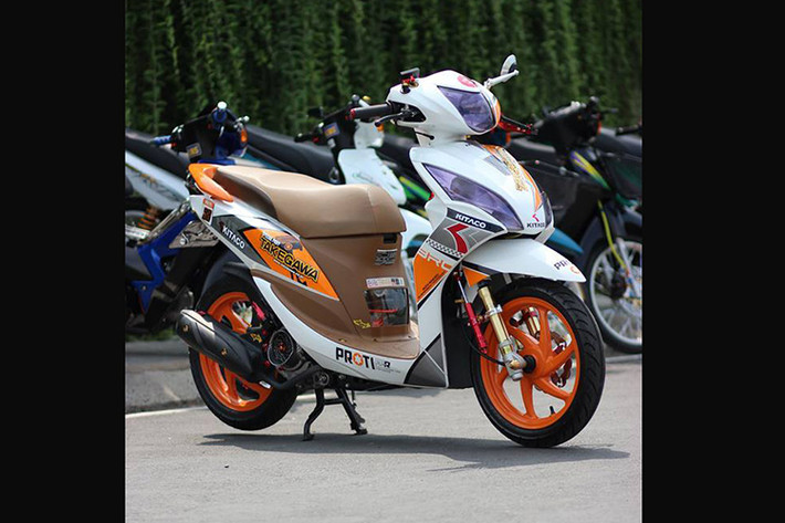 Chiếc xe ga Honda Vision độ này được "lột xác" hoàn toàn, nổi bật với tông màu trắng- cam đậm phong cách Honda Repsol cùng dàn tem được chủ xe độ lại bắt mắt và phong cách hơn so với nguyên bản .