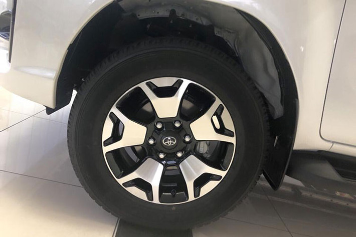 Trên cản va trước có cụm đèn sương mù cỡ nhỏ, nằm cạnh chi tiết trang trí hình chữ C mạ crôm. Riêng phần sườn và đuôi xe của Toyota Hilux 2018 mới không thay đổi đáng kể so với trước. Kính sau xe được gắn hệ thống sưởi, cùng với đó là hệ thống đèn sương mù LED và bộ vành hợp kim 18 inch nằm trong lốp chạy trên mọi địa hình.