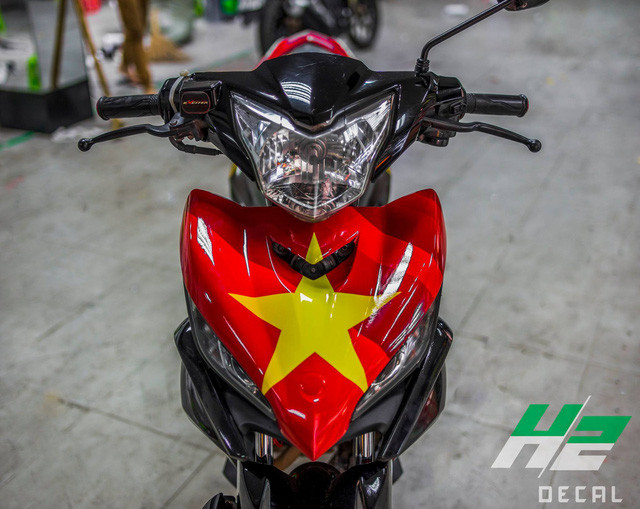 Phần mặt nạ phía trước, yếm xe 2 bên được dán decal cờ đỏ sao vàng nổi bật. Viền bánh xe cũng được dánh chi tiết màu đỏ giống chiếc BMW S1000RR. Các chi tiết còn lại cũng được phối màu đậm chất cá tính.