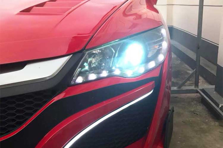 So với chiếc siêu xe NSX thật, bản độ này còn "ưu việt" hơn khi có thêm cặp đèn sương mù LED đầy hấp dẫn. Bên cạnh đèn sương mù, bộ đèn pha nguyên bản của Civic cũng đã được chế thêm các bóng LED nhỏ, tạo thành hàng "mí mắt" ở phía dưới. Để tăng tính thể thao cho chiếc xe, nắp ca-pô với các khe thoát nhiệt đã được bổ sung thêm cho Civic.