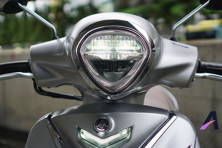 Ở phiên bản mới này, Yamaha Grande Hybrid có đèn pha hình viên kim cương, nhưng mềm mại hơn, có ốp viền crôm bóng, ứng dụng công nghệ LED. Trong khi đó ở phần đầu xe, mặt nạ của Yamaha Grande Hybrid 2018 có đôi chút thay đổi ở một số điểm nhấn như hình dạng đèn xinhan gọn gàng và mềm mại hơn trước đây.
