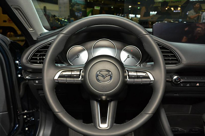 Với người lái, Mazda3 2019 chào đón bằng vô lăng có thiết kế mới và bảng đồng hồ đơn giản hóa với 3 đồng hồ hình tròn. Ngay bên dưới màn hình giải trí là các nút chỉnh điều hòa, nằm ngang hàng với cửa gió hình chữ nhật. Cụm điều khiển trung tâm xuất hiện cần số và các nút chỉnh hệ thống thông tin giải trí.