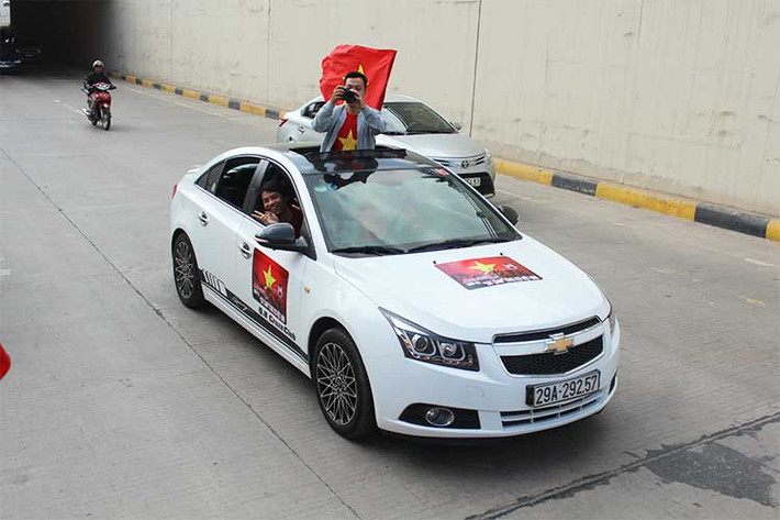 Một chiếc xe Chevrolet Cruze được trang trí cờ hoa và băng rôn cổ vũ cho đội tuyển U23 Việt Nam trước giờ bóng lăn chiều nay 23/1.