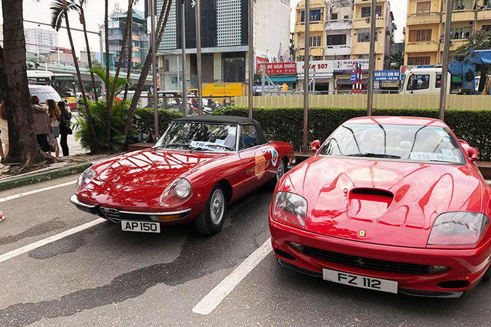 Trong đoàn xế cổ còn có một chiếc xe mui trần nữa là Alfa Romeo Spider (bên trái) được sơn màu đỏ rực rỡ. Là hậu duệ của Giulia Spider, Alfa Romeo Spider được sản xuất từ năm 1966 - 1993.