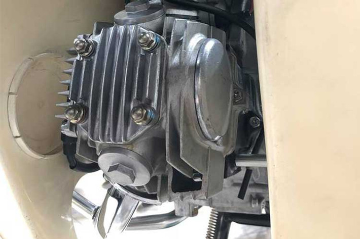 Bên dưới gầm xe, thân máy và cần khởi động của chiếc xe này cũng hoàn toàn sạch sẽ không hề dính bùn đất hay dầu mỡ. Bưởng máy của chiếc Dream này vẫn còn mới tinh, hoàn toàn không có một vết xước và lấp lánh ánh nhũ bạc như mới rời khỏi nhà máy của Honda Thái Lan.