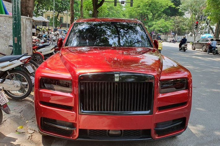 Đầu tiên chính là việc thay đổi một số chi tiết mạ crôm sáng bóng của SUV siêu sang Rolls-Royce Cullinan mang màu đỏ độc nhất Việt Nam sang màu đen. Chẳng hạn như các thanh nẹp bên hông, thanh chia gió ở hốc gió trước hay tay nắm cửa đều được sơn lại màu đen.