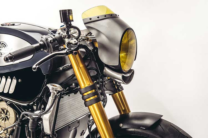 Bộ đèn LED kép nguyên bản của Panigale R hoàn toàn không ăn nhập với kiểu dáng của một chiếc cafe racer, chính vì vậy chóa đèn tròn màu vàng cổ điển đã được thay thế cho chiếc xe. Bao xung quanh bộ đèn, Raphael đã gò cho chiếc xe một chiếc quây gió mini. Đặc biệt, anh còn tự tạo ra một khe hút gió bằng nhôm nằm dưới đèn pha.