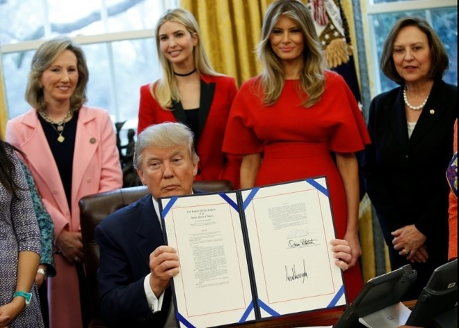Bà Melania cùng Ivanka Trump, con gái riêng với người vợ đầu Tổng thống Trump, trong lễ ký một sắc lệnh hành pháp tại Phòng Bầu dục của Nhà Trắng ngày 28/2. Ảnh: Reuters.