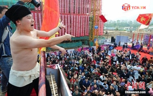 Để mở màn cho hoạt động quảng bá mới của công ty, một đại gia Trung Quốc đứng ở trên cao rải bao lì xì xuống phía dưới. Ước tính tổng giá trị các bao lì xì lên đến gần 50.000 nhân dân tệ (khoảng 170 triệu đồng). Ảnh: Chinanew.