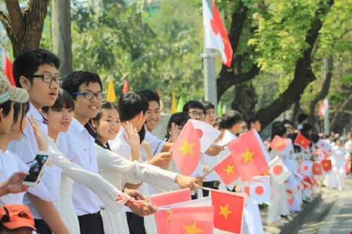 Học sinh, sinh viên đứng trên đường Lê Lợi vẫy tay chào tạm biệt nhà vua Nhật Bản Akihito và hoàng hậu Michiko cùng đoàn tùy tùng của Nhật hoàng đi qua. Ảnh: NGUYỄN DO