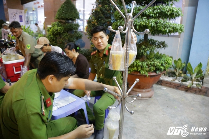 Các chiến sỹ công an đóng cháo để phát cháo cho người nghèo, bệnh nhân nghèo. (Ảnh: Quang Hải)