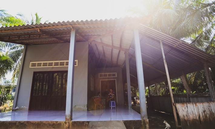 Để vào được nhà phải bước qua chiếc cầu ọp ẹp dựng tạm bằng gỗ và các bao cát bắc qua mương dẫn nước. Ảnh: Zing