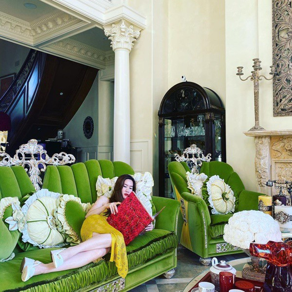 Phòng khách là sự kết hợp của hoa văn chạm trổ tinh tế, sofa màu xanh to, hoa tươi và nhiều món đồ trang trí đính đá quý. Ảnh: Instagram