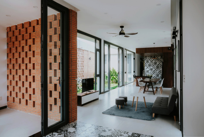 Nhà sử dụng gạch thô làm vật liệu chủ đạo kết hợp với gỗ óc chó tự nhiên trên nền sơn trắng. Ảnh: Cung Vit.