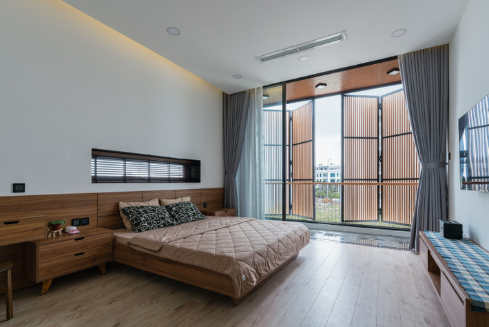 Phòng ngủ trên tầng 2 và phòng đọc sách trên tầng 3 lấy ánh sáng tự nhiên nhờ giếng trời làm bằng kính và bề mặt gỗ trên tầng thượng.