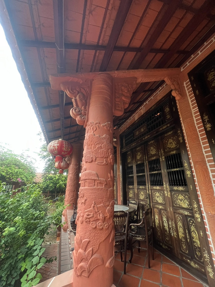 Tại 3 gian nhà có những hàng cột gốm phía ngoài mái hiên được chạm trổ hoa văn nổi theo chủ đề "Đất phương Nam", như: nông nghiệp lúa nước; lễ hội; cả nhà quây quần ăn Tết... Ảnh: Người lao động