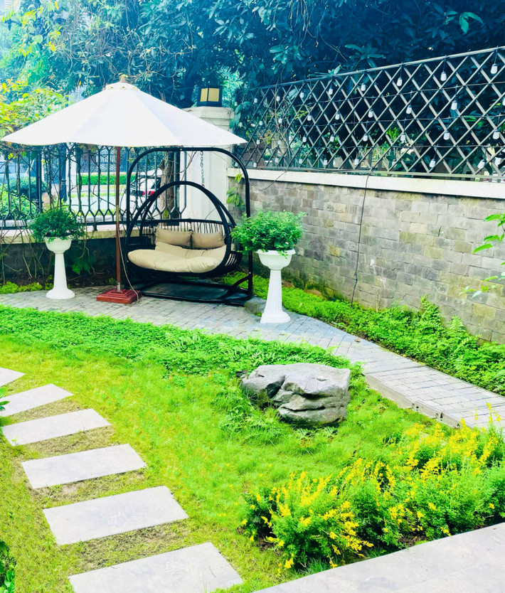 Khu vườn 150m2 được bố trí hồ cá và trồng nhiều cây xanh, hoa thơm quanh năm.