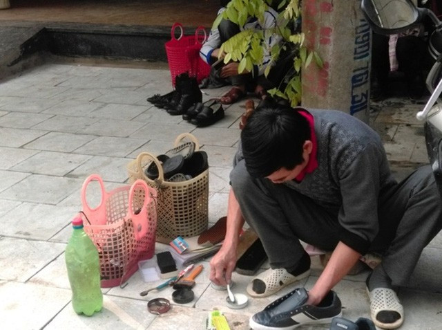 Gần khu vực các quán ăn, cà phê… những thợ đánh giày dạo dường như không nghỉ tay vì lượng khách quá đông so với thường ngày. Ảnh: Vietnamnet
