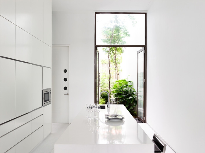 Thay vì bố trí trong nhà, kiến trúc sư chừa lại 1 khoảng diện tích để đưa khoảng thông tầng ra bên ngoài.