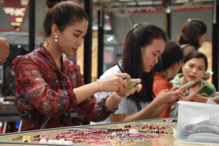 Khách đến tham quan và mua đá quý rất đa dạng, có cả những người buôn bán chuyên nghiệp đến từ nhiều nơi trên thế giới. Ảnh: Lao động