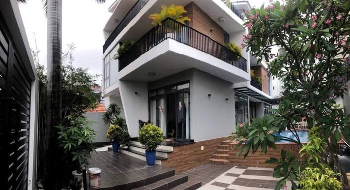 Căn biệt thự có gam màu trắng chủ đạo, phía trước là khoảng sân rộng rãi, thoáng mát. Ảnh: Lao động