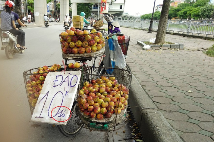 Trên các tuyến phố ở Hà Nội, không khó để bắt gặp những xe hàng rong sử dụng biển quảng cáo đánh lừa kiểu 1/2kg. Ảnh: Lao động