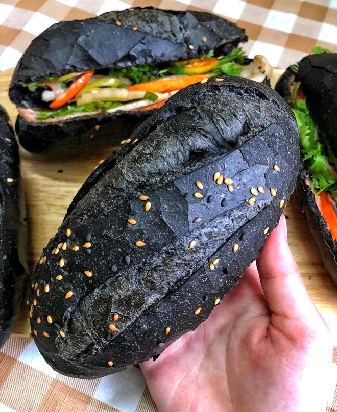 Bánh mì đen không bán rời mà được kẹp cùng 6 loại nhân như chả mực, cua bể, xíu mại tôm, gà nướng, bò nướng phô mai và heo quay với mức gia dao động khoảng 20.000-45.000 đồng. Ảnh: Zing.
