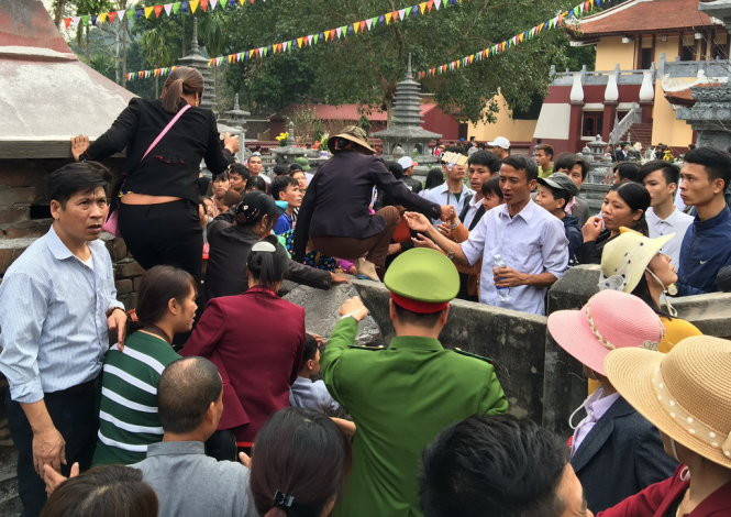 Cảnh tượng du khách trèo tường, dẫm đạp hoa màu để giành đường vào chùa Hương ngày khai hội. Ảnh: Tuổi Trẻ.