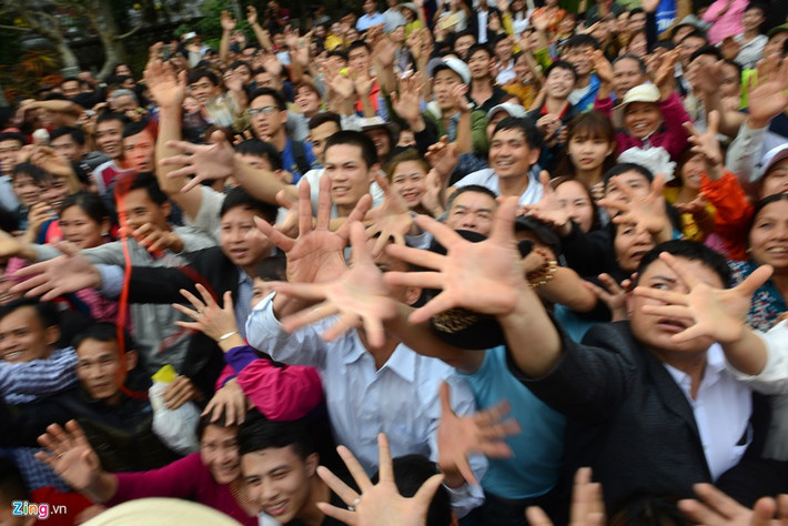 Ban đầu sư thầy tặng tận tay từng du khách, phật tử, đến khi quá đông người không thể chia tiếp lúc này lộc được phát lên không trung, hàng trăm cánh tay cùng vươn ra đón lấy.